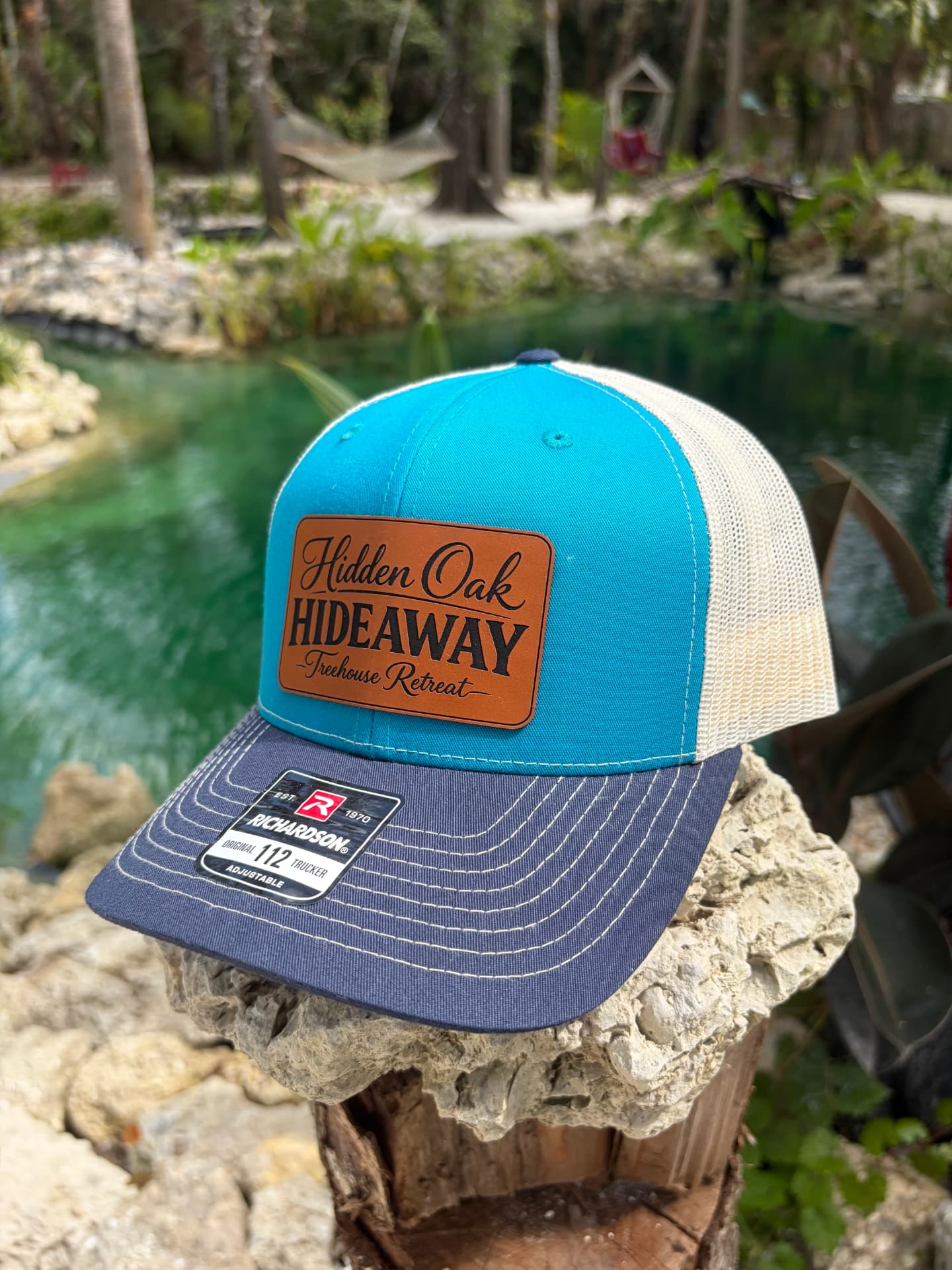 Teal and navy Hidden Oak Hideaway trucker hat with leather patch